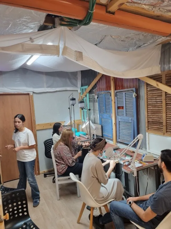 חברי מועדון היוצרים עובדים יחד בעמדות הסטודיו בגן יבנה